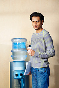 饮水机摄影照片_一名男子站在饮水机旁