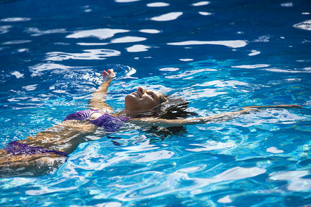 一名女子在游泳池里做仰泳