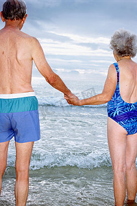 一对成熟的情侣在海滩上手牵手