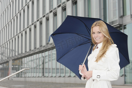 下着雨摄影照片_一名女子在城市街道上打伞