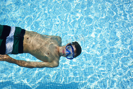 十几岁的男孩在游泳池里戴着护目镜