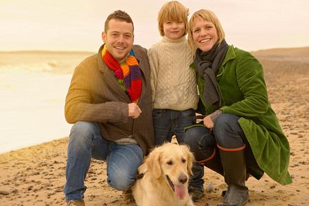 一家人带着狗在海滩上秋天秋天