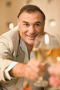 一位商人举起一杯葡萄酒干杯