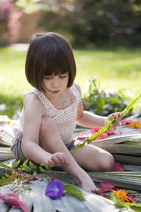 带着蕨类植物的女孩在花园里摆放花叶