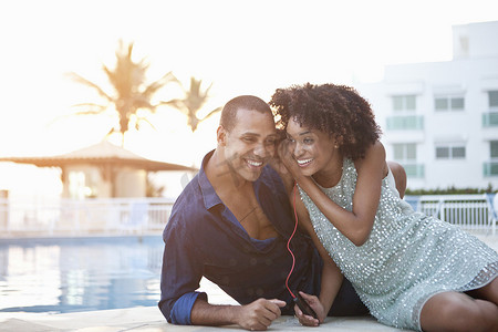 巴西里约热内卢一对时尚情侣在池边共享耳机