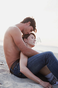 情侣拥抱坐在沙滩上