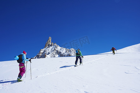 三名成年滑雪者爬上法国格拉尼亚阿尔卑斯山的勃朗峰