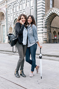 意大利托斯卡纳佛罗伦萨圣玛丽亚·诺维拉广场一对女同性恋打着手机撑着伞微笑着看着相机