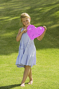 爱情标题摄影照片_年轻女孩抱着粉色的纸心