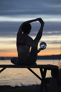 日落时分在湖边练习瑜伽的女子