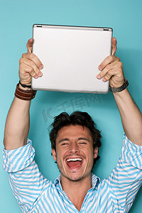 怒气条摄影照片_一名男子举起笔记本电脑