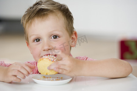 一盘饺子摄影照片_吃着甜饺子的小男孩