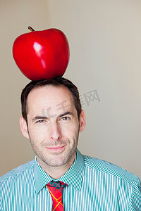 头上戴着超大苹果的男人