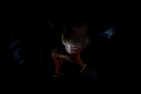 男孩在黑暗中使用手机