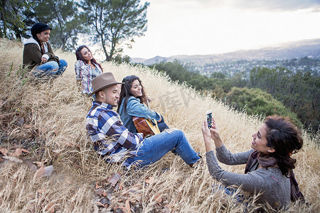 一名年轻女子在草地上为她的四个成年兄弟姐妹拍照
