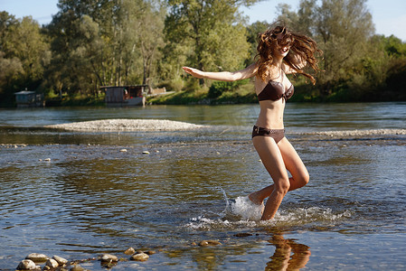 穿着比基尼的年轻女子在河里嬉水玩耍