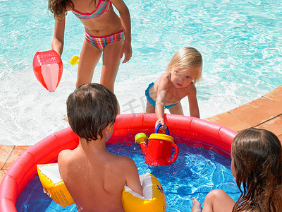 四个孩子在儿童泳池里玩耍