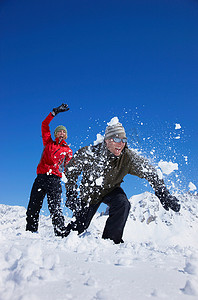 雪地里玩耍摄影照片_一对年轻夫妇在雪地里玩耍