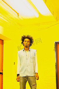 黄色灯光摄影照片_一名男子站在黄色房间里