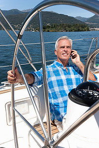 一位老人在帆船上打电话