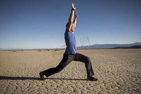 海市蜃楼摄影照片_男人训练在干燥的湖床上伸展手臂美国加利福尼亚州海市蜃楼