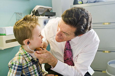 男医生在医生办公室让小男孩玩听诊器