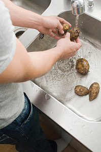 鲜活农产品摄影照片_洗土豆的男人