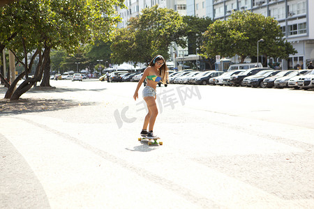 巴西里约热内卢科帕卡巴纳人行道上的年轻女子滑板