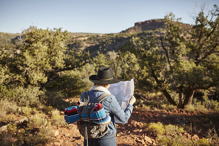 美国亚利桑那州塞多纳乡村环境中的妇女看着地图后视镜