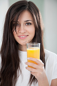 一杯橙汁摄影照片_拿着一杯橙汁的女人