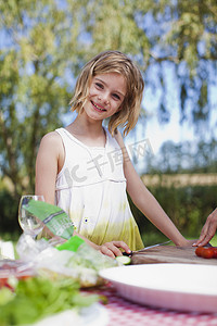 野餐桌摄影照片_做野餐的年轻女孩