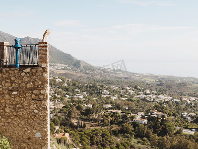阳台植物摄影照片_站在阳台上看风景的中年妇女西班牙安达卢西亚米哈斯