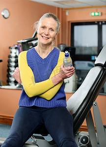 年长的女性在健身房喝水