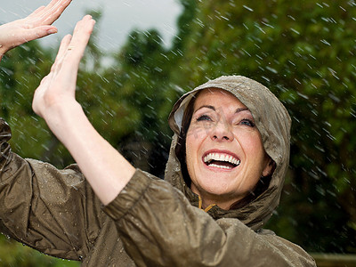 下着雨摄影照片_雨中微笑的女人