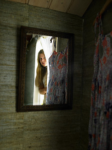 十几岁女孩在卧室门口凝视的镜子