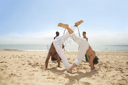 赤口摄影照片_男人们在海滩上做卡波埃拉