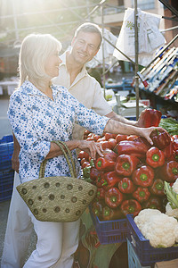 西班牙马略卡岛一对情侣在市场上挑选辣椒