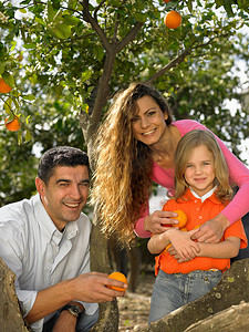 年轻的女孩和带着橙子的父母