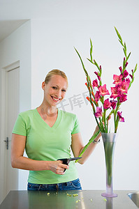 室内家族摄影照片_微笑的女人在花瓶里插花