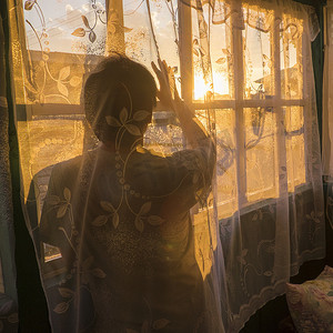 神秘摄影照片_中年男子在网帘后面看着窗外的日落后视线