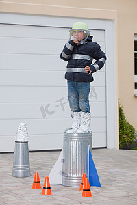火箭般的摄影照片_站在自制火箭上的男孩