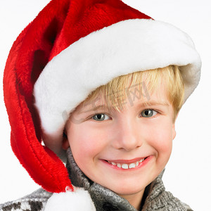 戴圣诞帽的男孩摄影照片_戴着圣诞帽的男孩