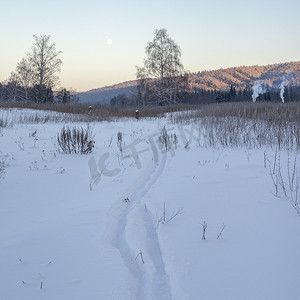 风景摄影照片_俄罗斯斯维尔德洛夫斯克村白雪覆盖的风景中远处的烟囱烟雾和森林