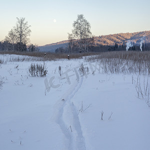 俄罗斯斯维尔德洛夫斯克村白雪覆盖的风景中远处的烟囱烟雾和森林