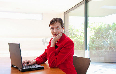 坐在电脑前的人摄影照片_光办公室里坐在电脑前的女人