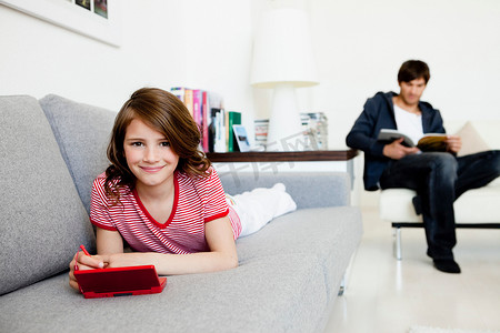 女孩玩电子游戏爸爸读书