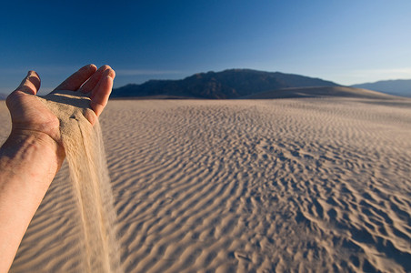 美国加利福尼亚州死亡谷国家公园里的手持沙