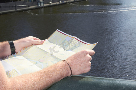 一名男子在桥上阅读城市地图