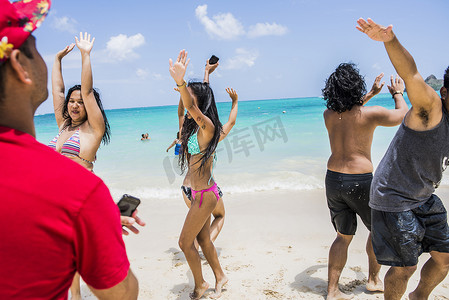 年轻的成年朋友在美国夏威夷瓦胡岛的拉尼凯海滩跳舞