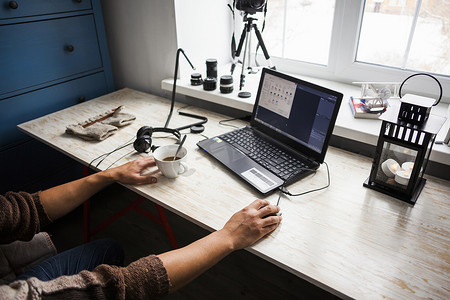 鼠标符号摄影照片_中年男子坐在办公桌前使用笔记本电脑中段
